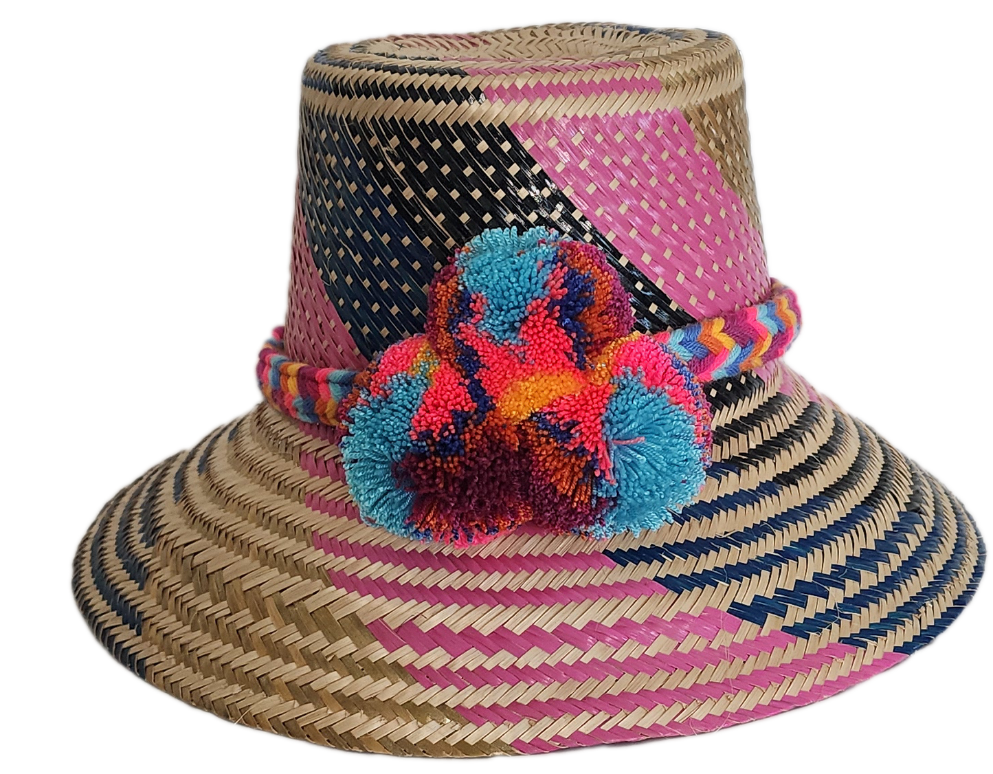 Boho Wayuu straw hat with vibrant pink, navy, and natural woven design, a multicolor braided band, and playful pom-poms in turquoise, red, and orange — a colorful, handcrafted bohemian summer accessory.