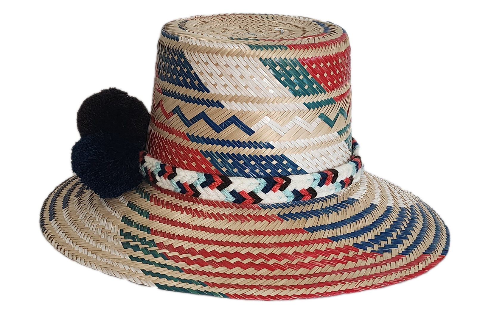 Boho Wayuu straw hat featuring vibrant red, navy, and green woven patterns, a hand-braided multicolor band, and bold red and black pom-poms — a colorful, handcrafted bohemian accessory perfect for summer.