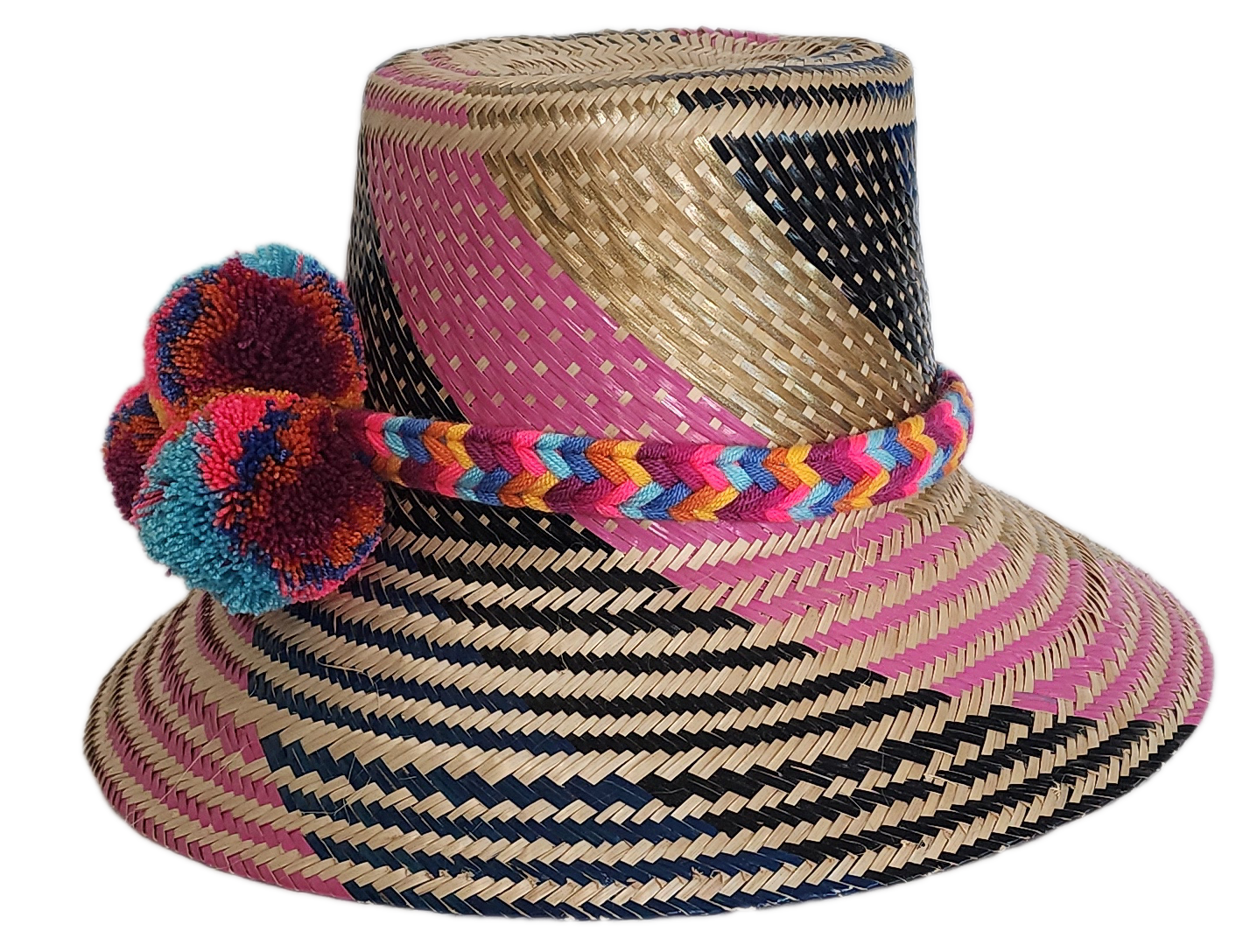 Boho Wayuu straw hat with vibrant pink, navy, and natural woven design, a multicolor braided band, and playful pom-poms in turquoise, red, and orange — a colorful, handcrafted bohemian summer accessory.