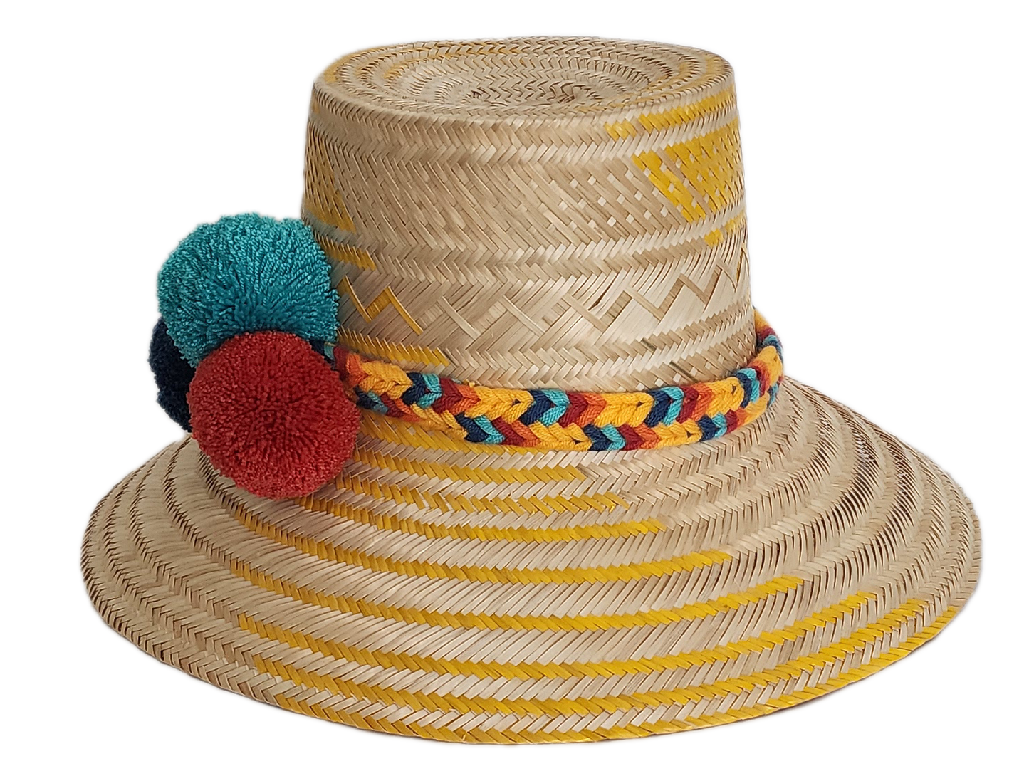 Boho Wayuu straw hat with yellow zigzag woven accents, a vibrant braided band, and colorful pom-poms in teal, red, and navy — a handcrafted bohemian accessory perfect for sunny days.