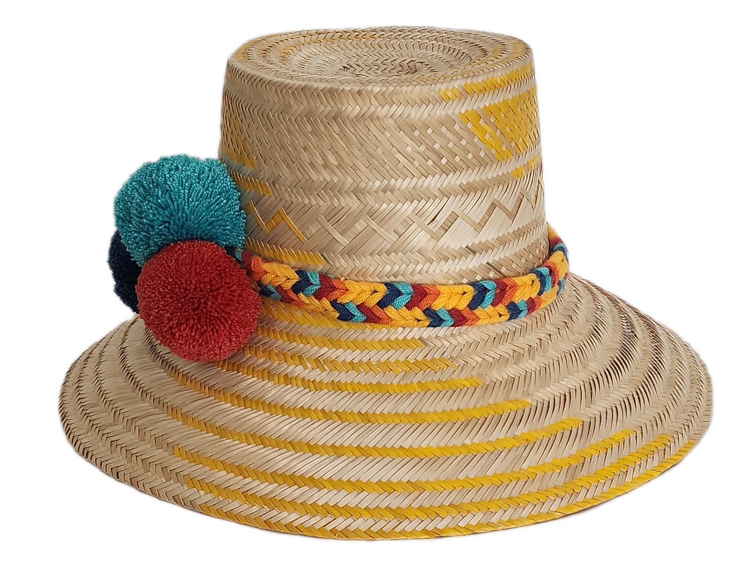 Boho Wayuu straw hat with yellow zigzag woven accents, a vibrant braided band, and colorful pom-poms in teal, red, and navy — a handcrafted bohemian accessory perfect for sunny days.