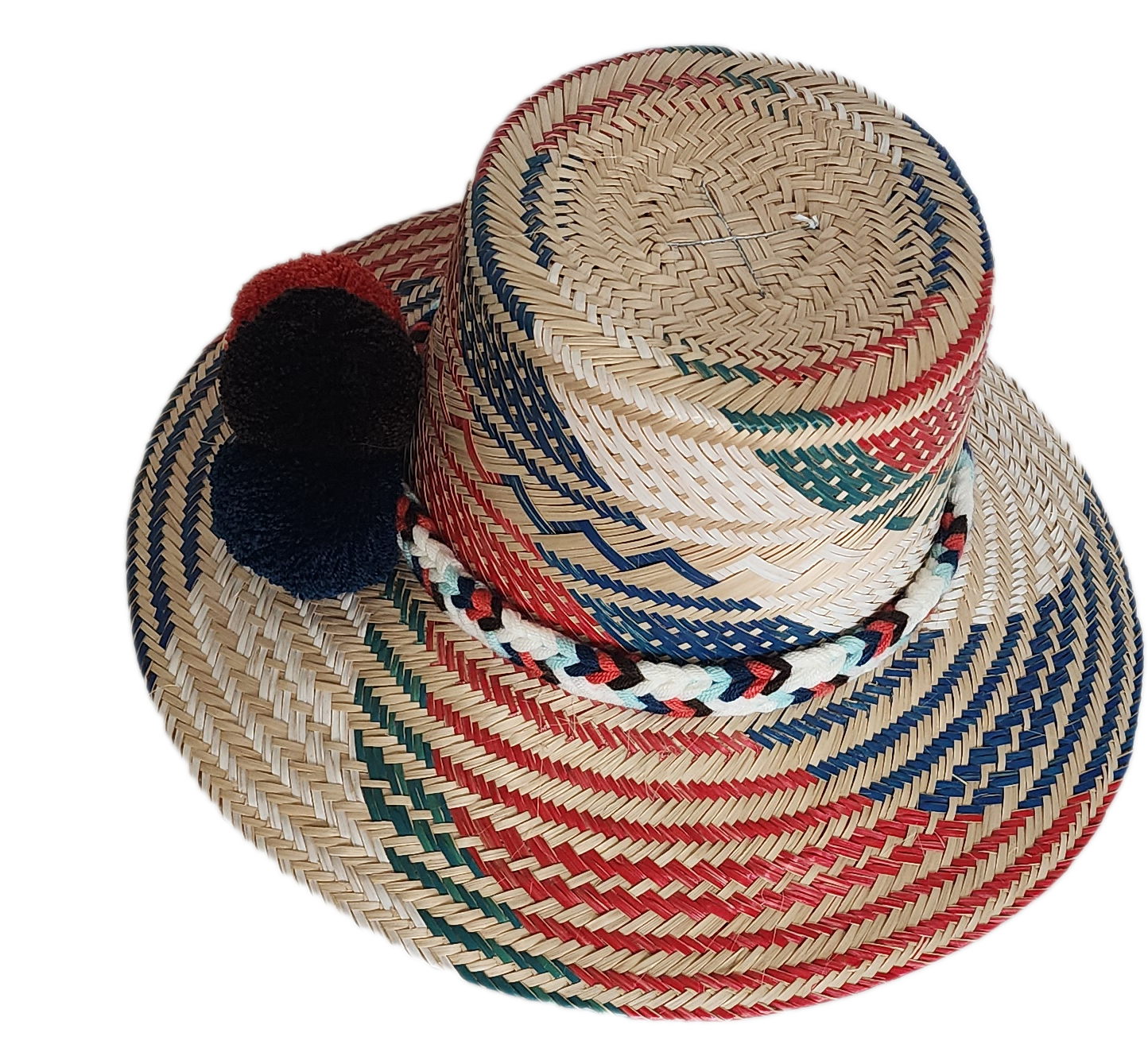 Boho Wayuu straw hat featuring vibrant red, navy, and green woven patterns, a hand-braided multicolor band, and bold red and black pom-poms — a colorful, handcrafted bohemian accessory perfect for summer.