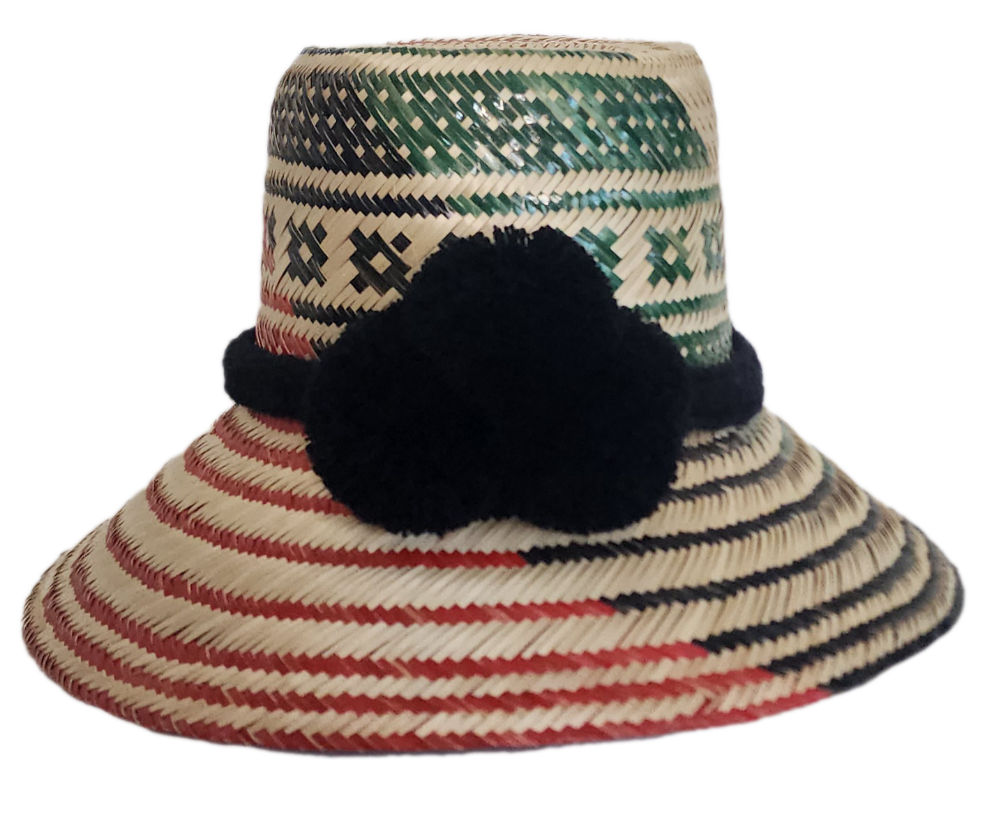 A vibrant, handmade straw hat featuring green and black geometric patterns on the crown and red and black stripes on the brim, accented by a bold black pompom band.