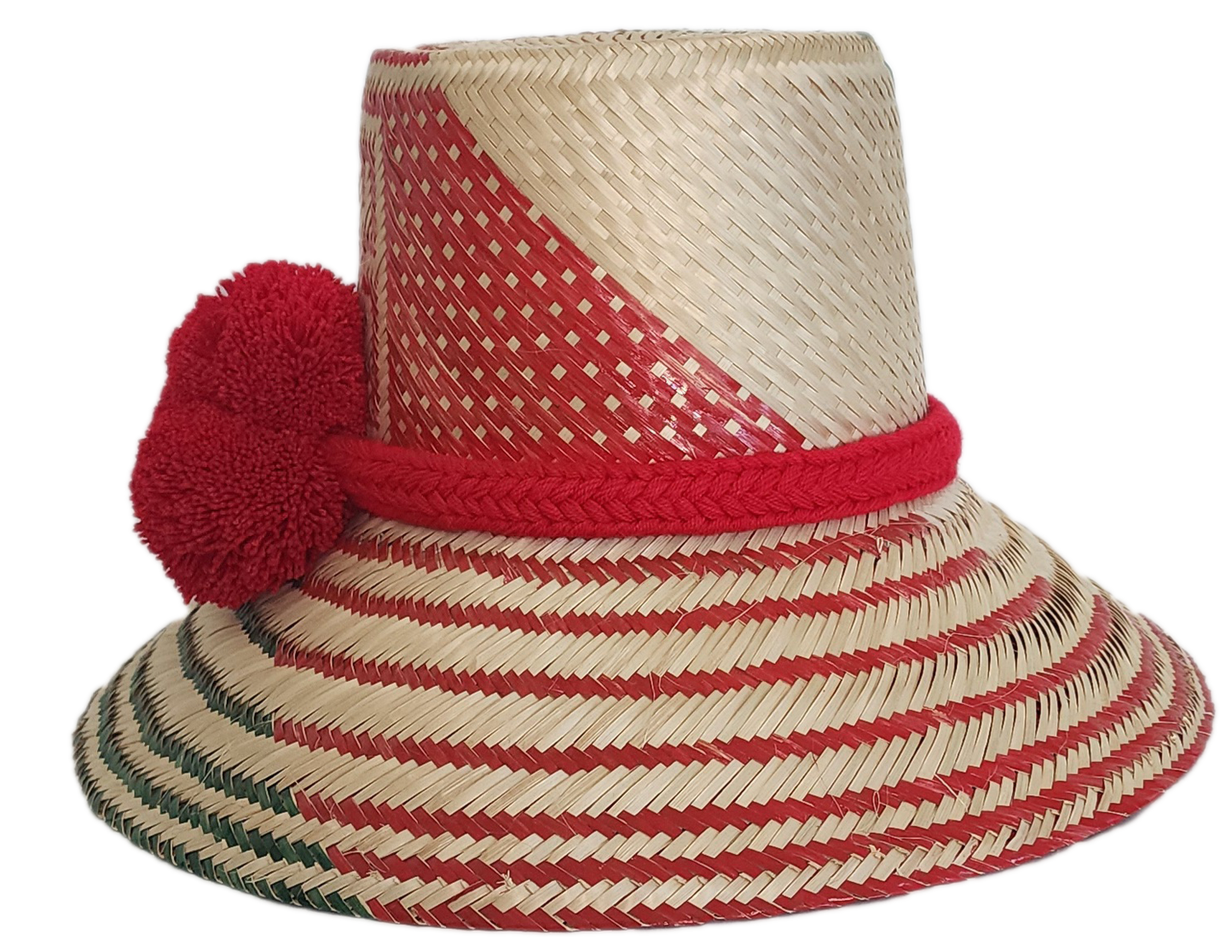 A vibrant, handmade straw hat featuring red and green geometric patterns and a bold red pompom band with three fluffy pompoms.