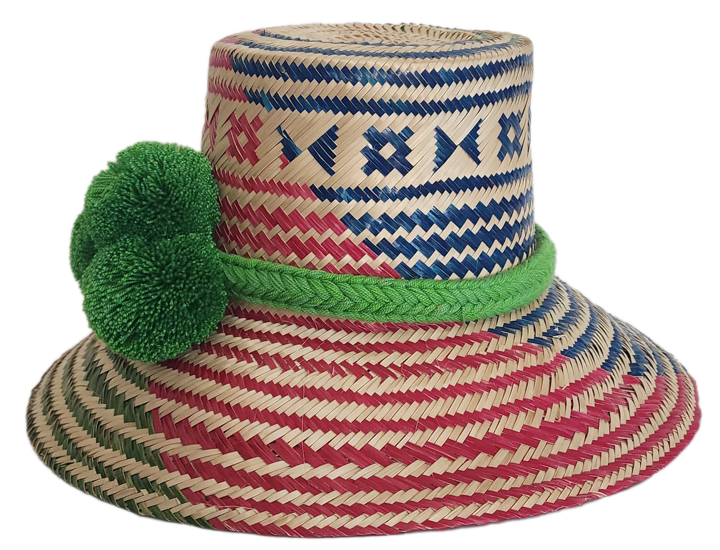 A colorful, handmade straw hat with red, blue, and green geometric patterns and a vibrant green pompom band with three fluffy pompoms.