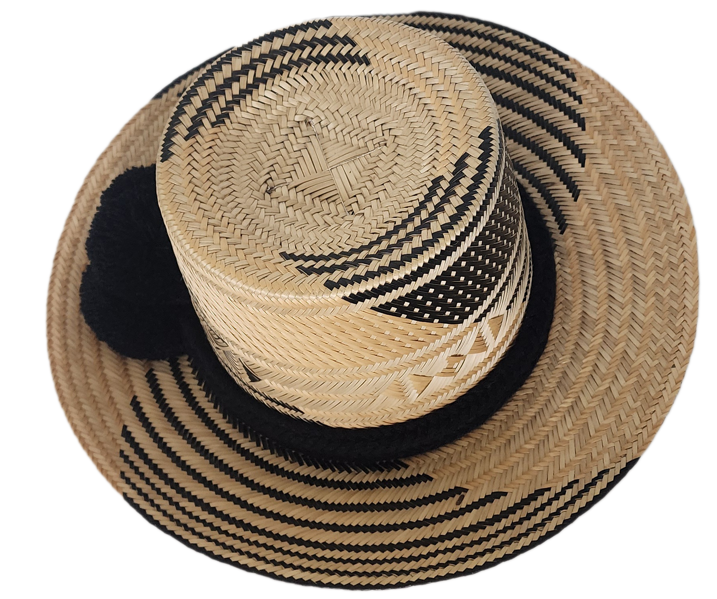 A stylish, handmade straw hat featuring intricate black and natural straw weaving patterns and a bold black pompom band.