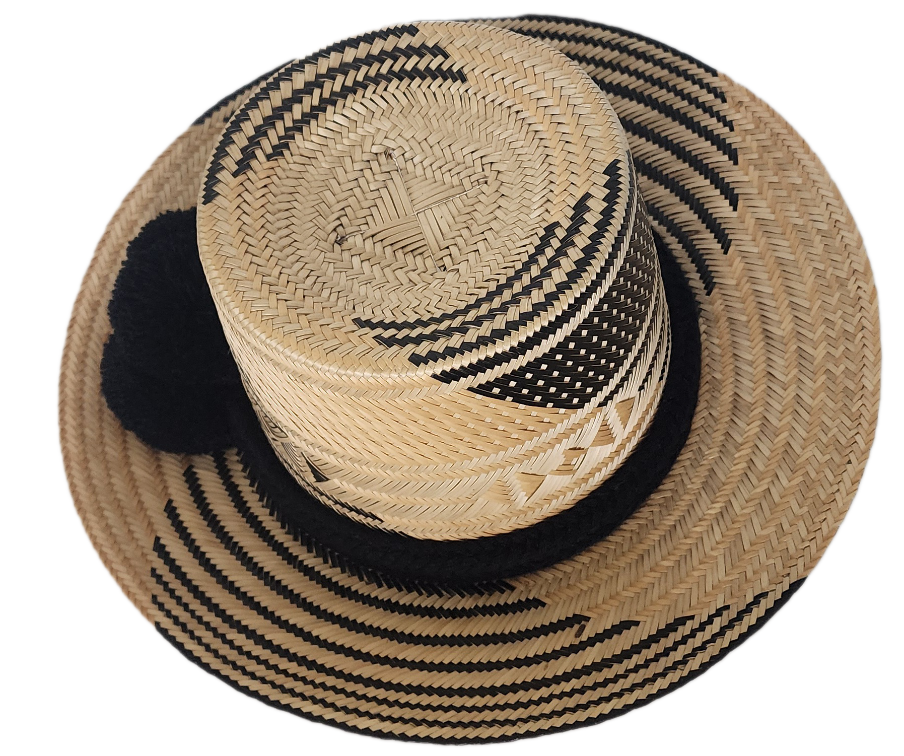 A stylish, handmade straw hat featuring intricate black and natural straw weaving patterns and a bold black pompom band.