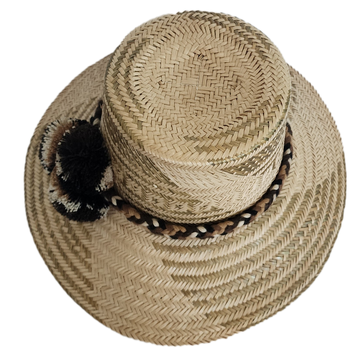 A stylish, handmade straw hat featuring intricate light and dark straw geometric patterns and a unique band with black, brown, and cream twisted elements and a black and brown pompom.