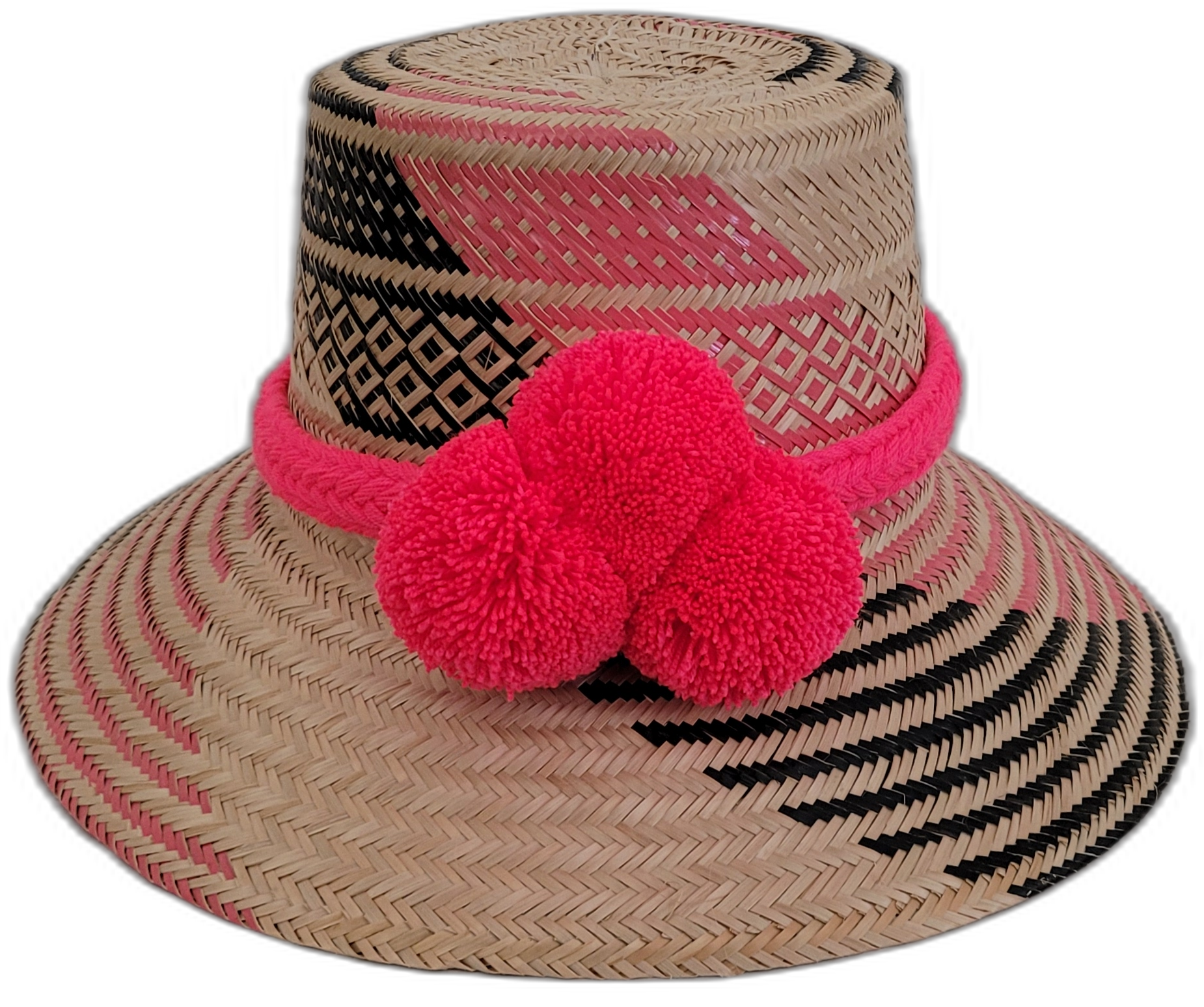 Handmade Wayuu straw hat with bold pink and black patterns, featuring large pink pompoms, perfect bohemian chic style.