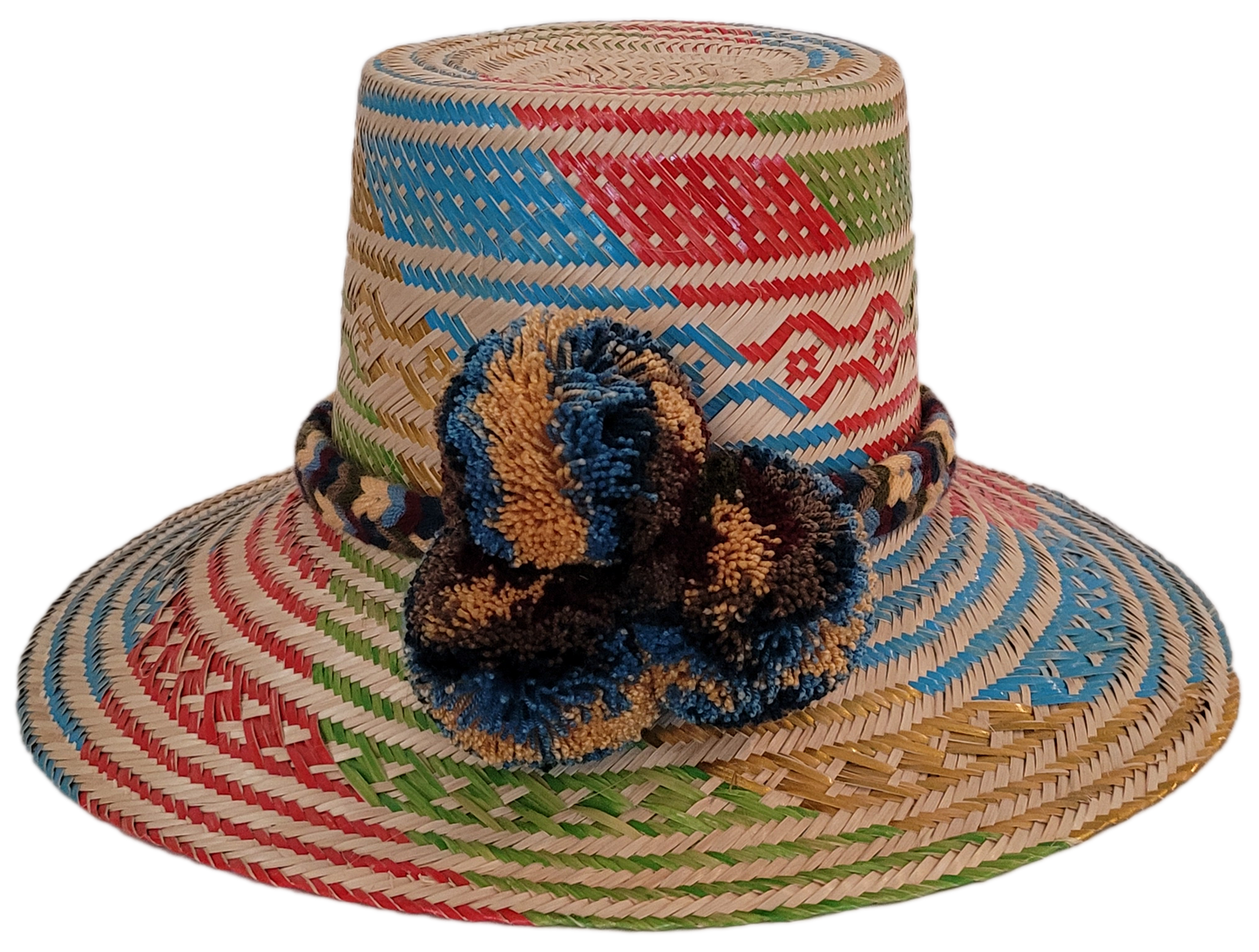 Handmade Wayuu straw hat with colorful weave and earth-toned pompoms
