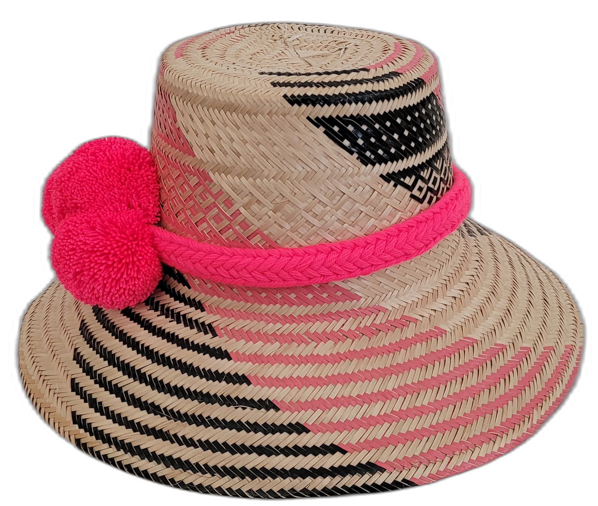 Colorful boho straw hat, crafted by Wayuu artisans, showing intricate pink and black woven patterns and handmade pompoms.