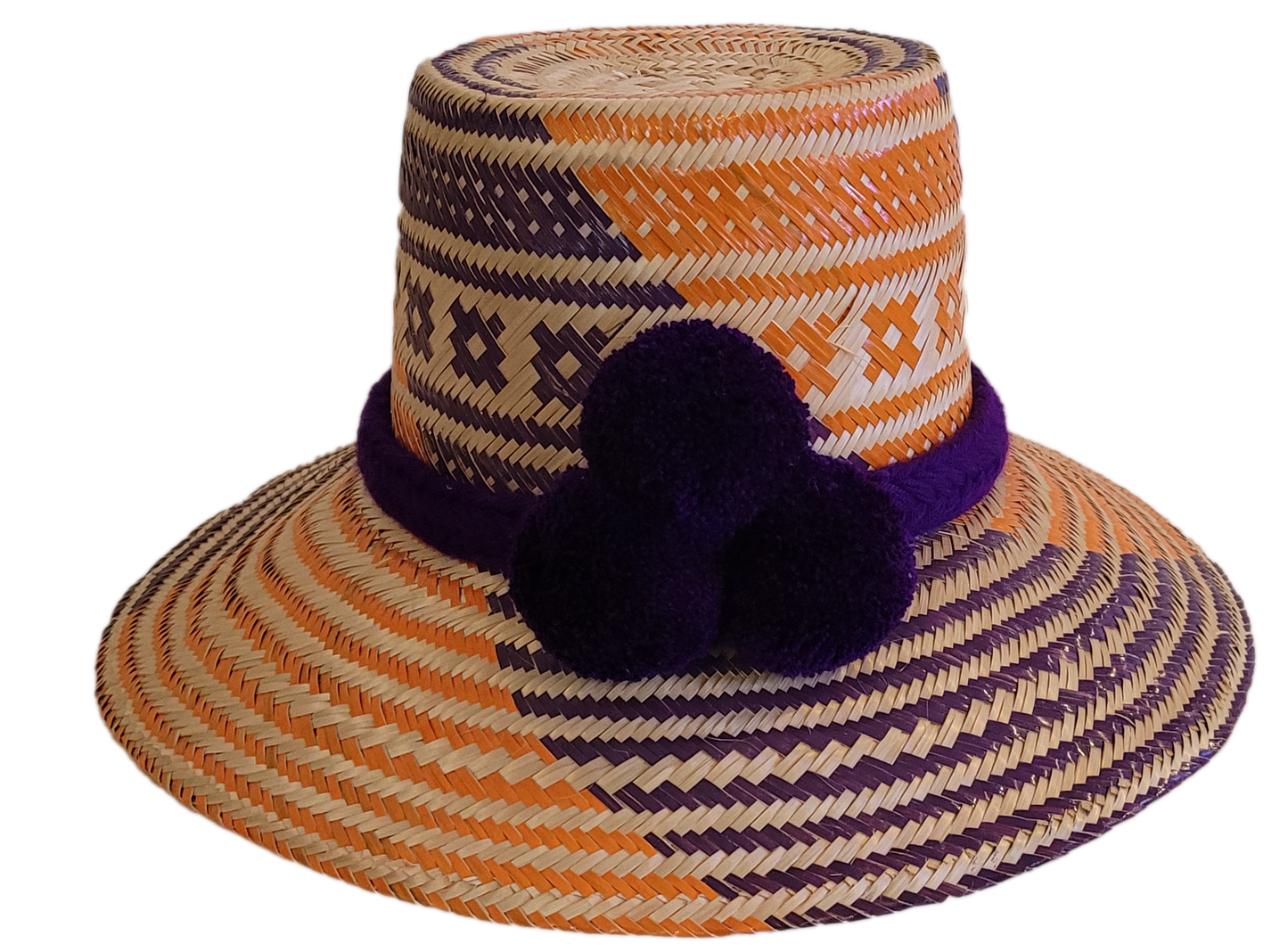 Handmade Boho straw hat in orange and purple with triple pompoms, crafted by Wayuu artisans.
