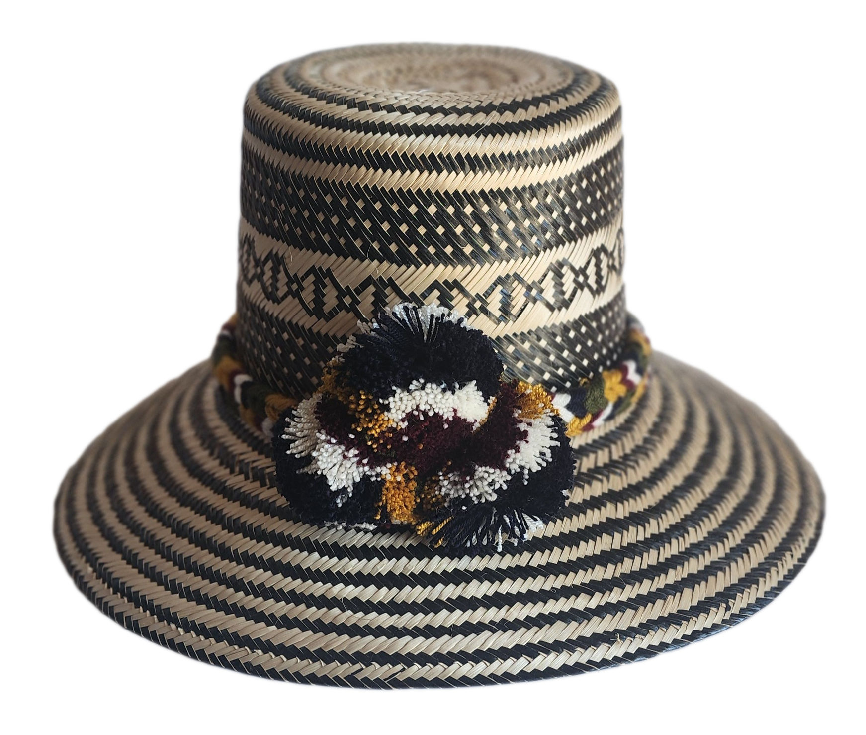 "Colorful handmade Wayuu hat crafted from Iraca palm with decorative pompoms, symbolizing wealth in Wayuu culture."
