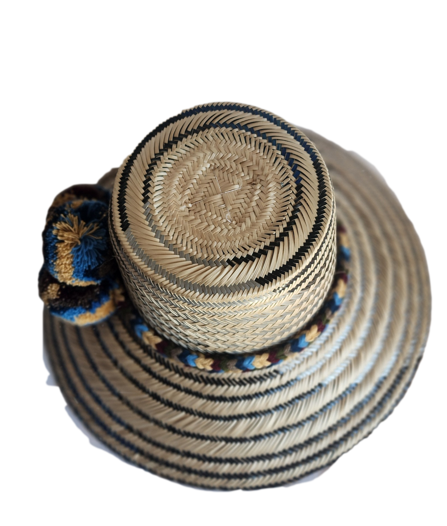 "Colorful handmade Wayuu hat from Colombia and Venezuela, woven from Iraca palm fibers with cultural pompoms."