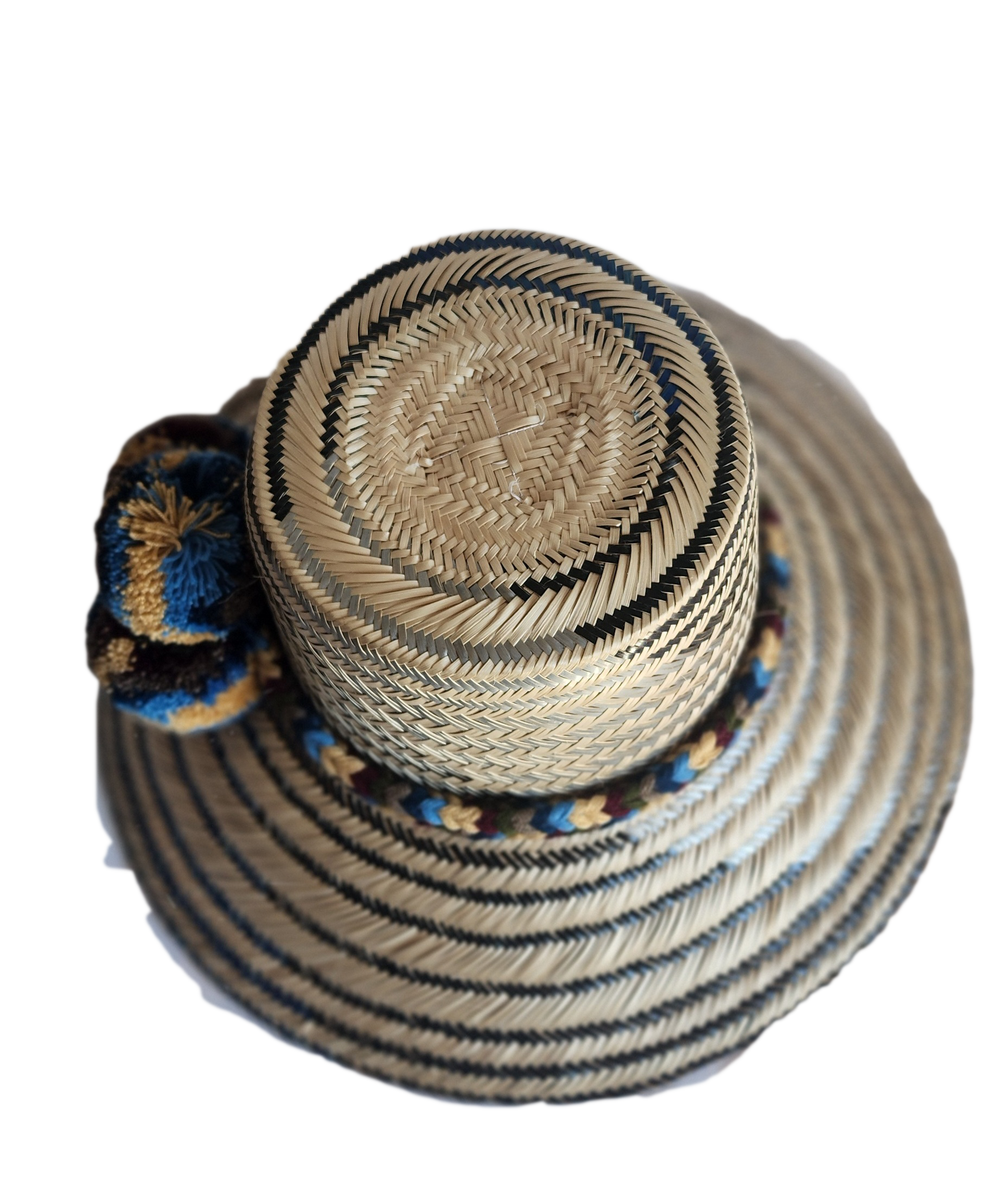 "Colorful handmade Wayuu hat from Colombia and Venezuela, woven from Iraca palm fibers with cultural pompoms."