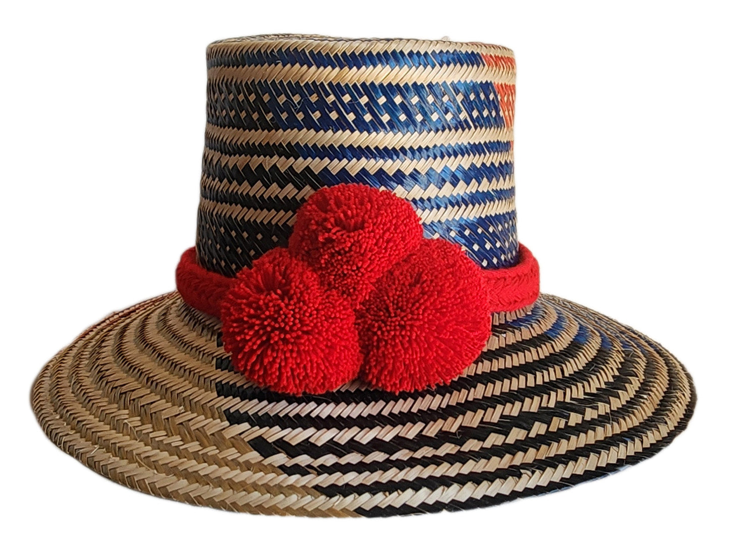 "Colorful handmade Wayuu hat woven from Iraca palm fibers, adorned with significant pompoms, adjustable for various sizes."