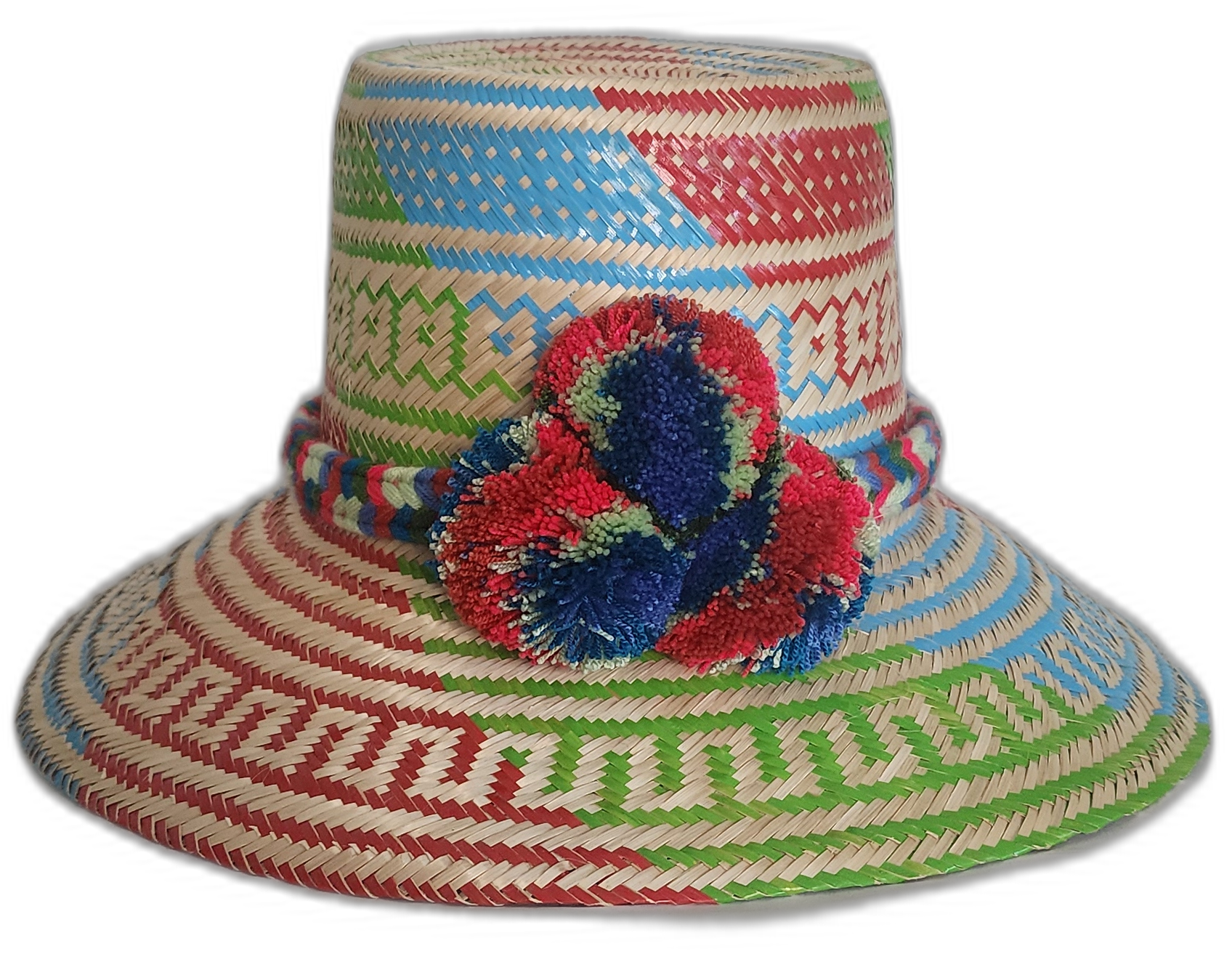 Handmade Wayuu boho straw hat with vibrant red, blue, and green woven patterns and bold pompom accents.