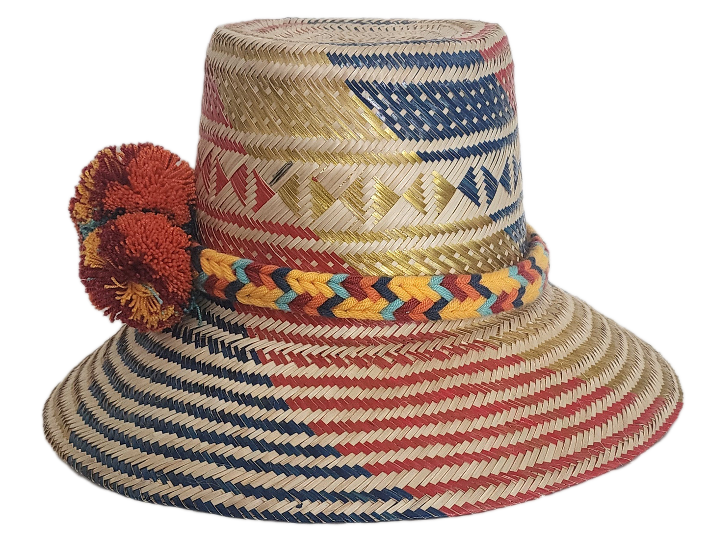 Handwoven Wayuu straw hat featuring red, navy, and golden tribal patterns, accented with a colorful braided band and vivid orange and maroon pom-poms.