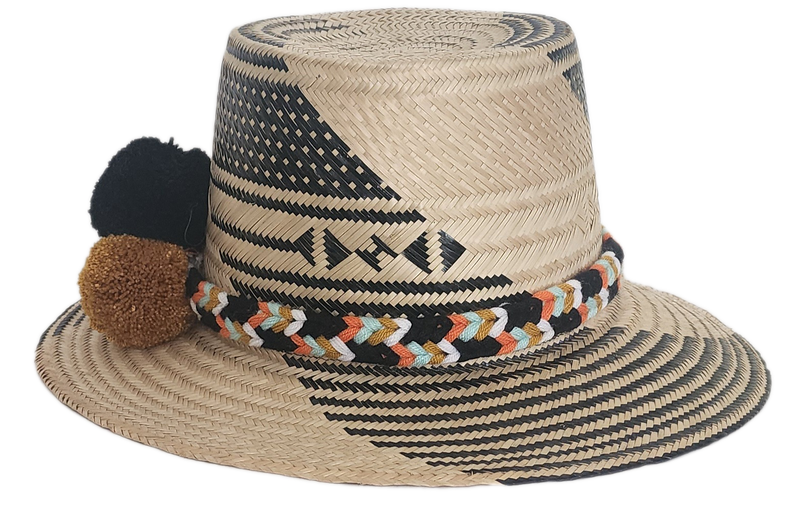 Handwoven Wayuu straw hat with bold black diagonal weave, a colorful braided band, and black, white, and mustard pom-poms. A refined boho fashion piece.