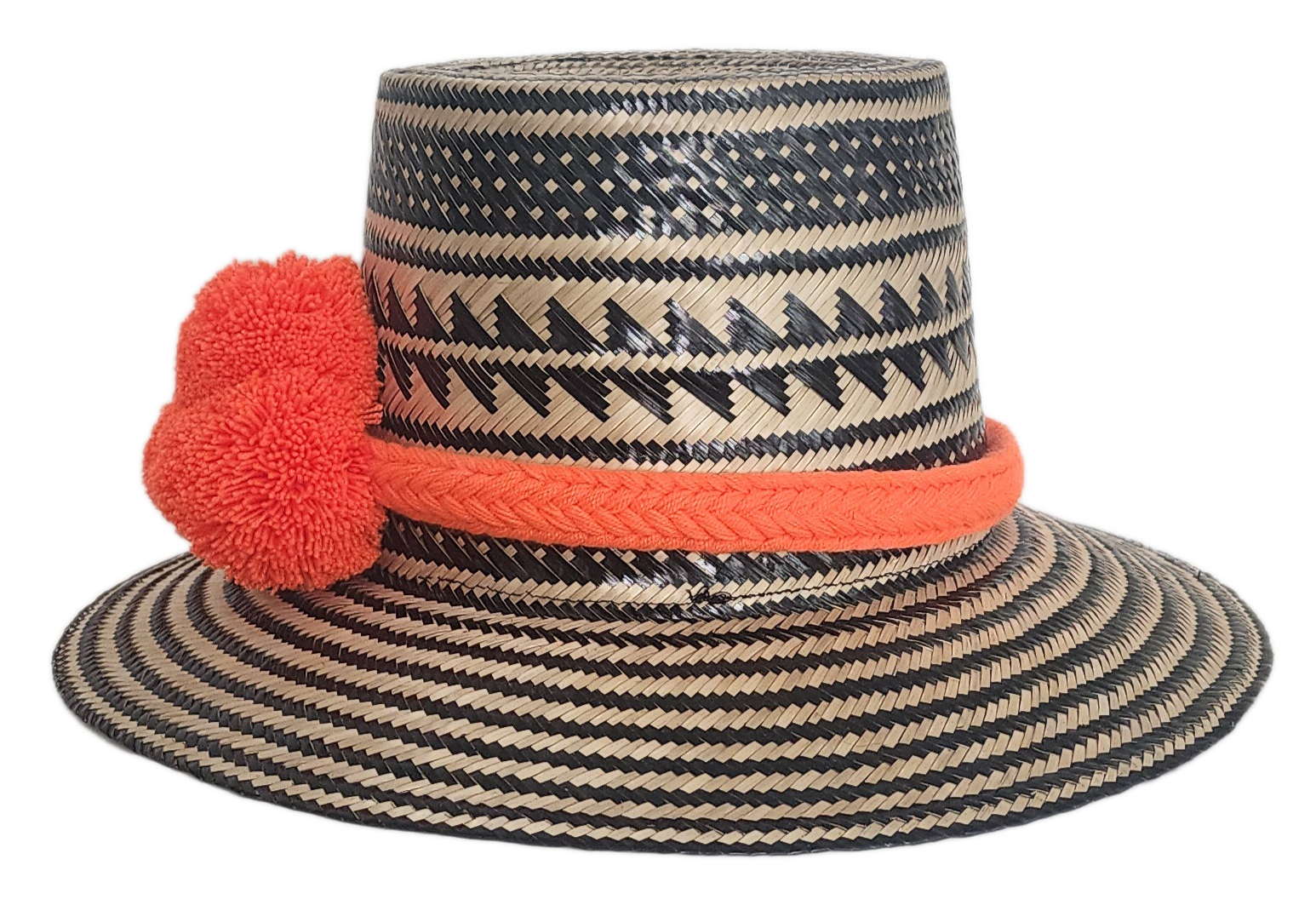 Handwoven Wayuu straw hat with black zigzag tribal patterns and a bold orange pom-pom band. A vibrant artisan boho accessory with modern contrast.