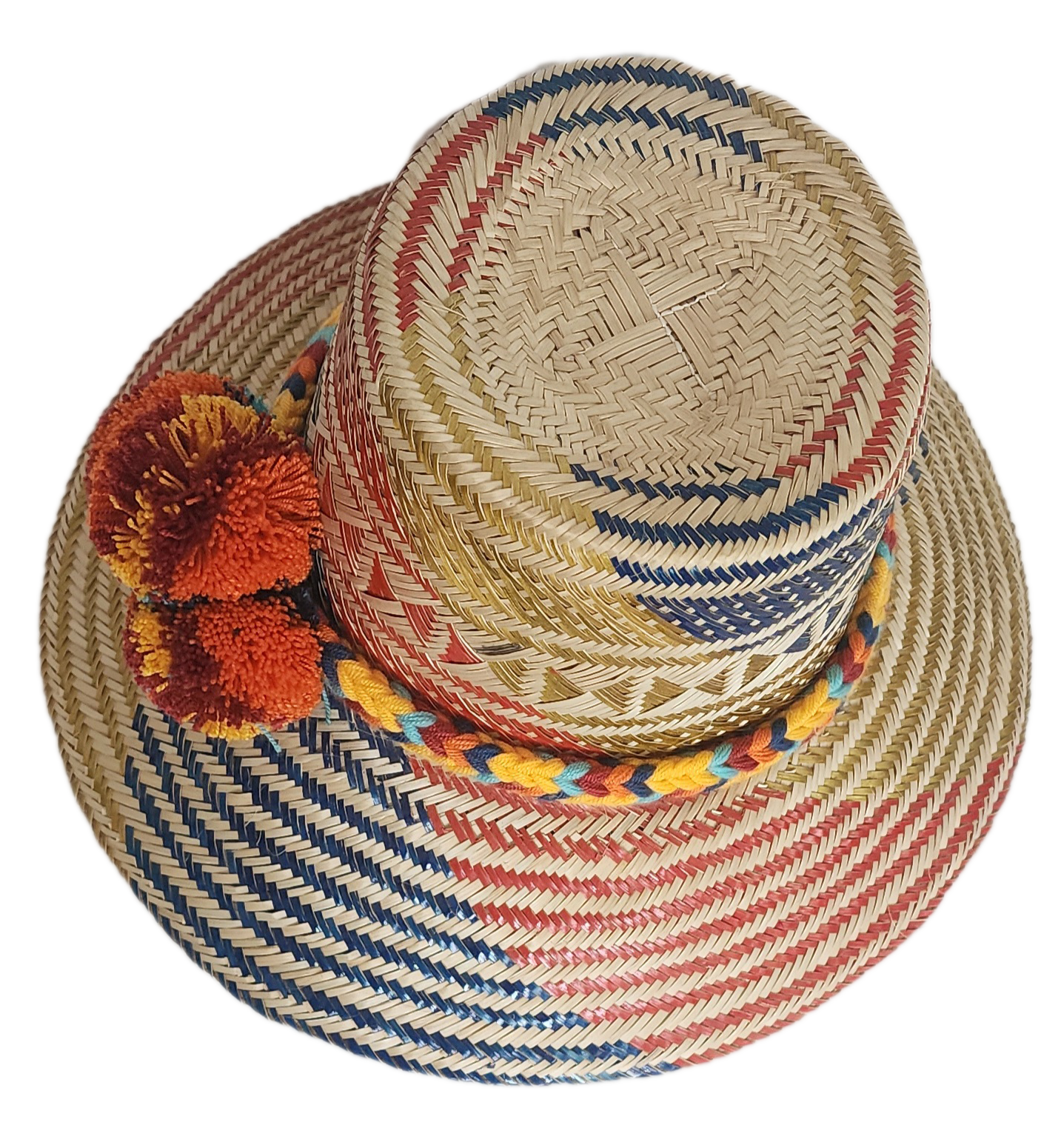 Handwoven Wayuu straw hat featuring red, navy, and golden tribal patterns, accented with a colorful braided band and vivid orange and maroon pom-poms.