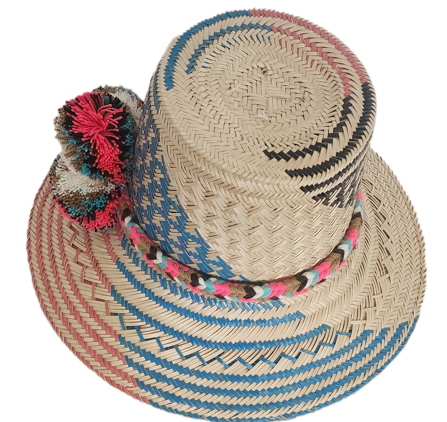 Colorful Wayuu straw hat featuring woven blue, pink, and natural patterns with a bright multicolor pom-pom band. A bold, handcrafted boho fashion piece.