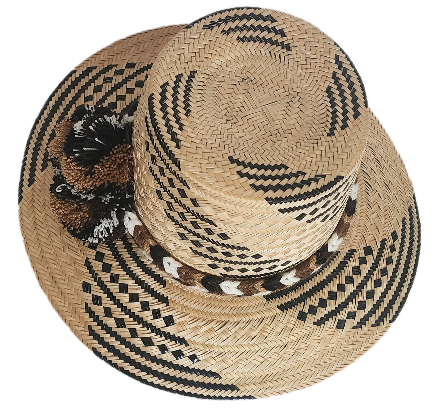 Handwoven Wayuu straw hat with black and brown geometric patterns, a braided band, and matching pom-poms. A rich, artisan-crafted boho accessory.