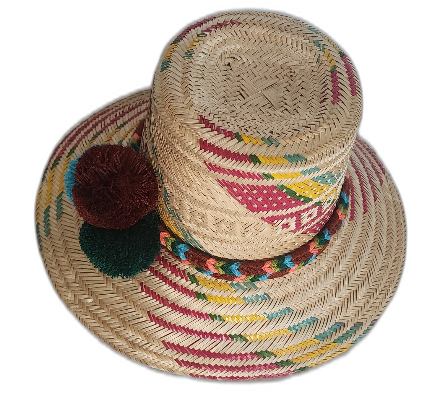 Bohemian straw hat crafted by Wayuu artisans with earth-toned patterns and artisan pompoms.