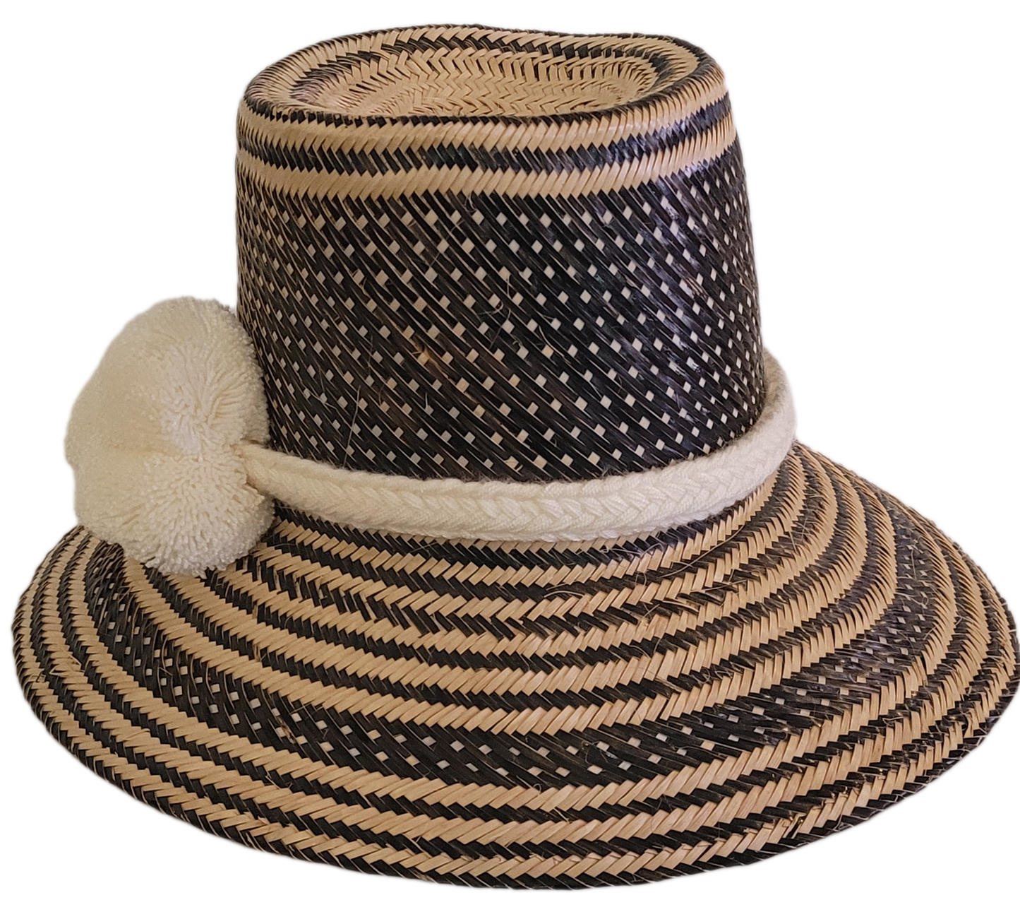 Artisan Wayuu straw hat featuring a bold black weave and soft white pom-poms — a bohemian essential with elegant contrast and handcrafted charm.