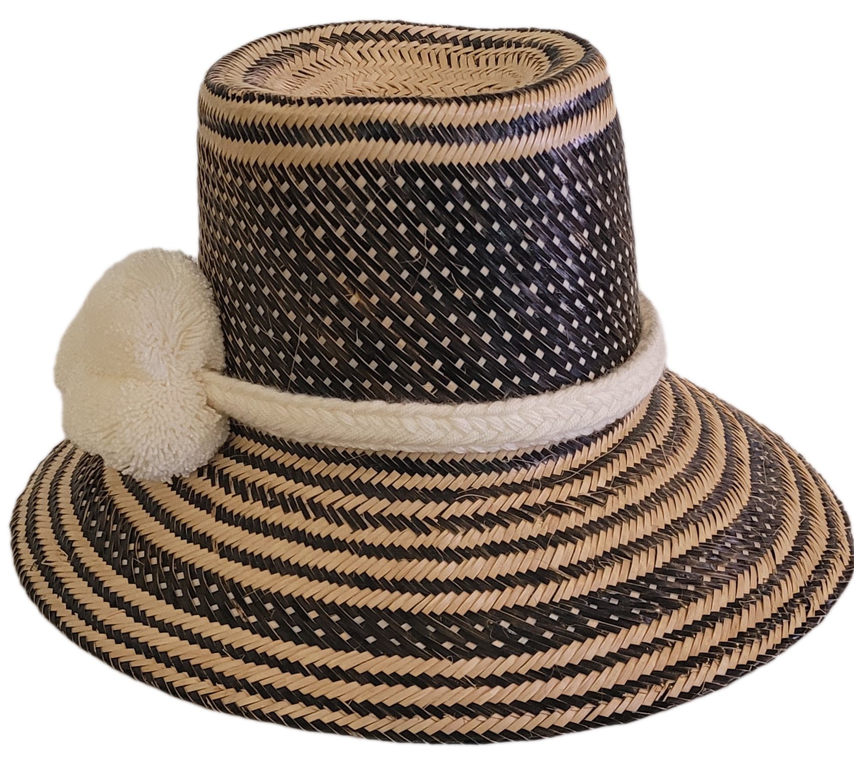 Artisan Wayuu straw hat featuring a bold black weave and soft white pom-poms — a bohemian essential with elegant contrast and handcrafted charm.