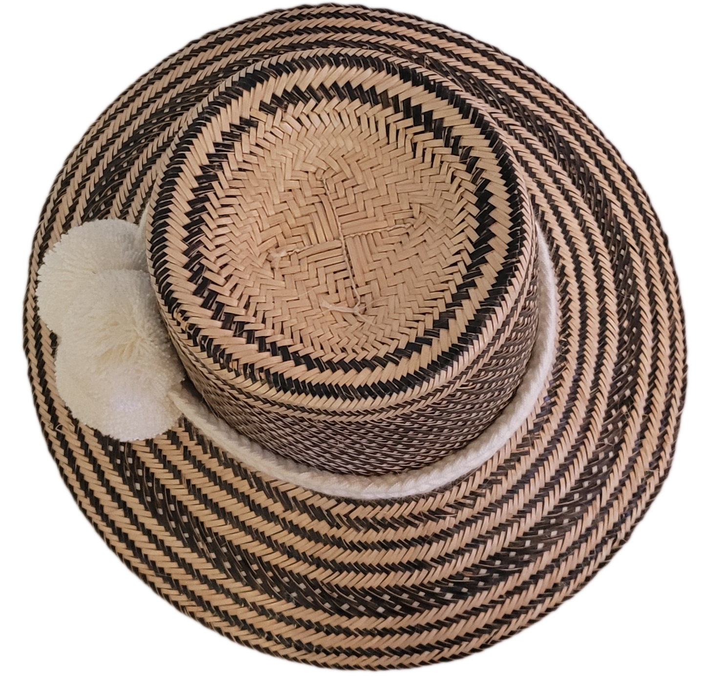 Black and natural handcrafted Wayuu hat with minimalist white pompoms and a textured band — boho fashion piece with understated artisan elegance.