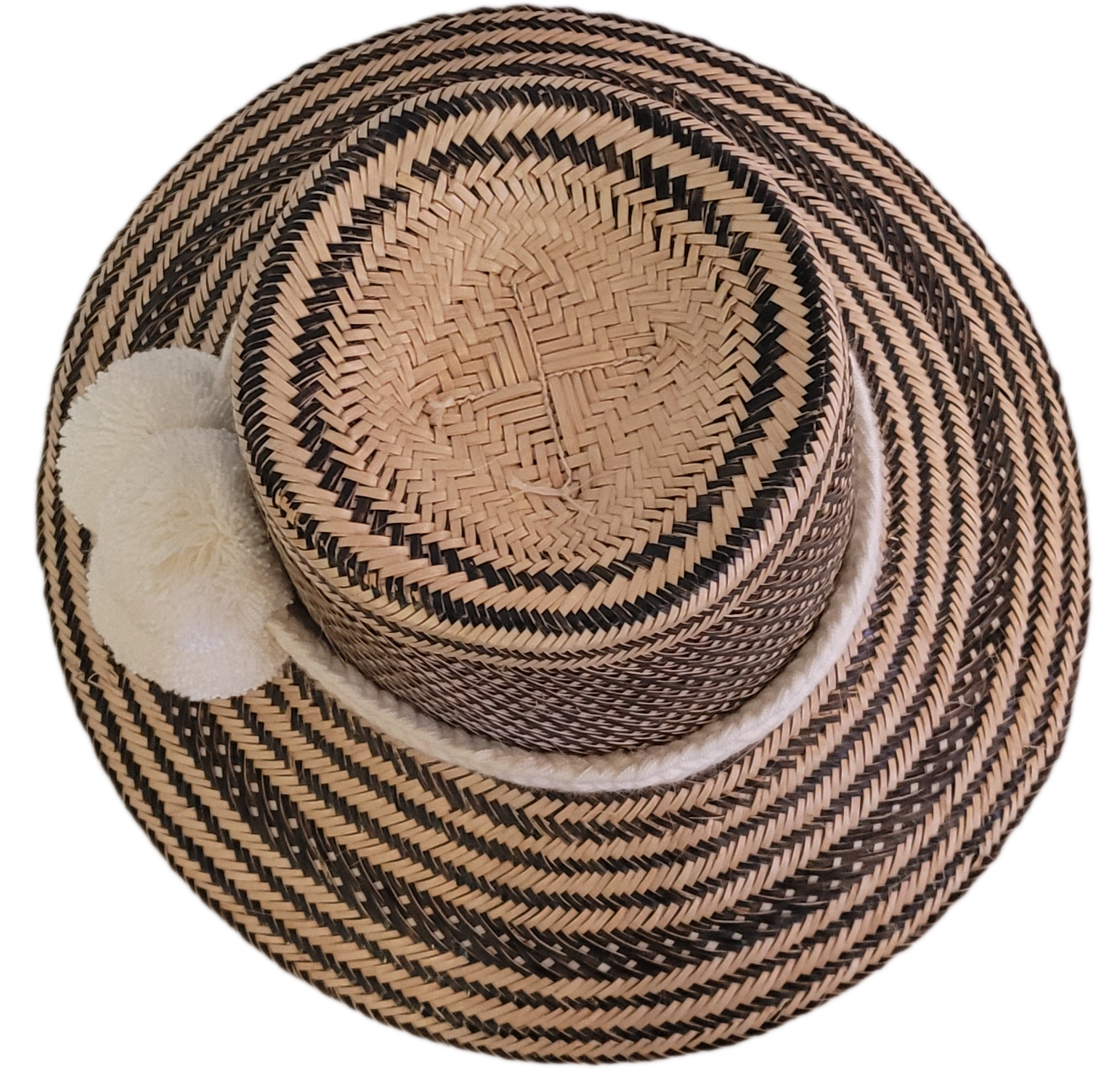 Black and natural handcrafted Wayuu hat with minimalist white pompoms and a textured band — boho fashion piece with understated artisan elegance.