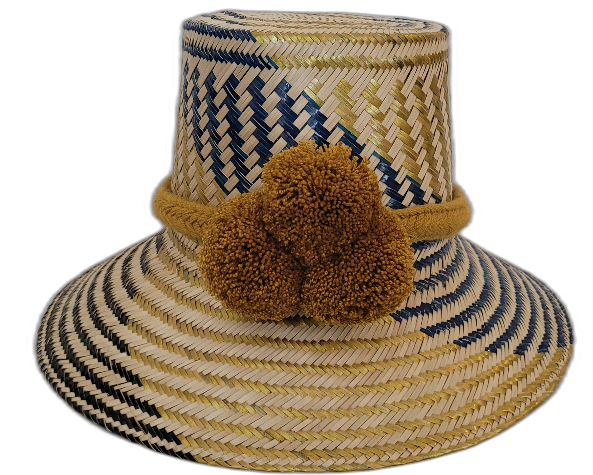 Handmade Wayuu straw hat with golden-brown pompoms and navy blue chevron weave.Boho straw hat in natural and dark blue tones with artisan pompoms