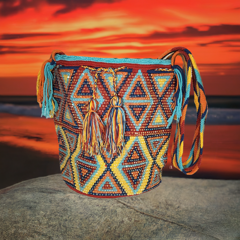 Handmade Wayuu crochet bag with colorful triangle patterns and tassels.