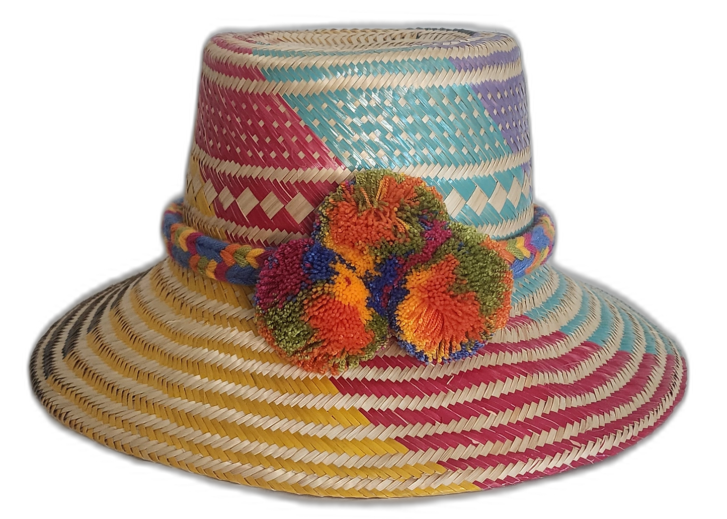 Handmade Wayuu straw hat with bold pink, blue, yellow, and purple weave and colorful orange pompoms.