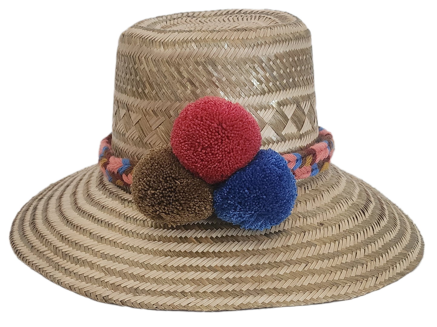 Handwoven Wayuu straw hat with colorful braided band and red, brown, and blue pom-poms — a boho, artisanal summer accessory.