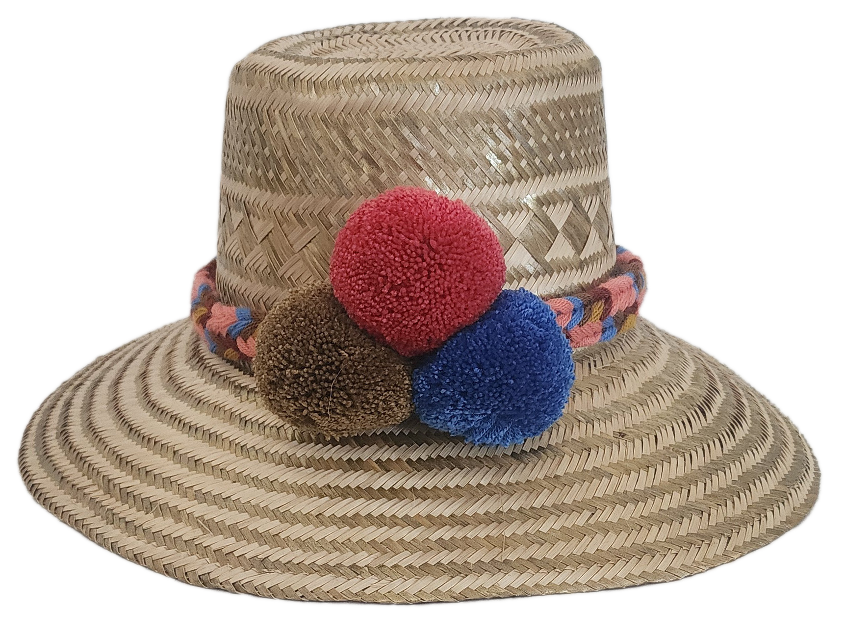 Handwoven Wayuu straw hat with colorful braided band and red, brown, and blue pom-poms — a boho, artisanal summer accessory.