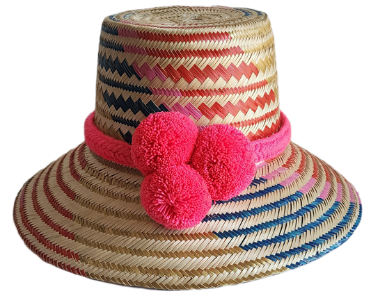 "Colorful handmade Wayuu hat from Iraca palm fibers, adorned with culturally significant pompoms, showcasing unique weaving b