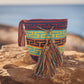 Image ALT text: "Colorful handmade crochet Wayuu bag showcasing boho and bohemian styles, crafted by Wayuu artisans from Colombia and Venezuela. Features vibrant, intricate crochet patterns typical of the Guajira Peninsula, adjustable handwoven straps, and designed for both style and functionality. Perfect for a beach day or adding a splash of color to everyday wear, supporting Fair Trade and Wayuu Taya Foundation."