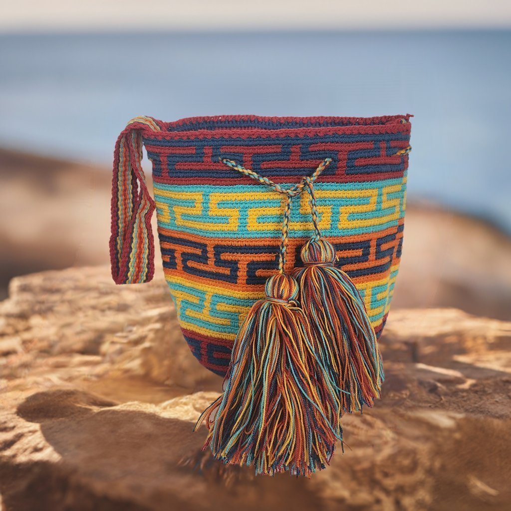 Image ALT text: "Colorful handmade crochet Wayuu bag showcasing boho and bohemian styles, crafted by Wayuu artisans from Colombia and Venezuela. Features vibrant, intricate crochet patterns typical of the Guajira Peninsula, adjustable handwoven straps, and designed for both style and functionality. Perfect for a beach day or adding a splash of color to everyday wear, supporting Fair Trade and Wayuu Taya Foundation."