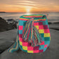 Image of a colorful, handmade crochet Wayuu bag featuring intricate bohemian patterns. This boho crossbody bag, created by indigenous Wayuu artisans from Colombia and Venezuela, showcases vibrant colors and geometric motifs inspired by the Guajira Peninsula. The bag varies in size and includes adjustable straps, making it both stylish and functional for everyday use or beach outings.