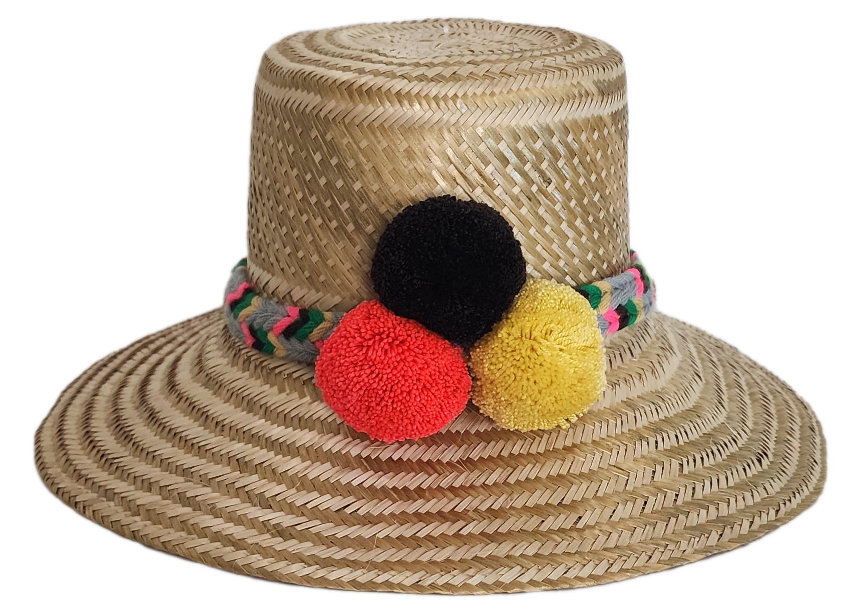 Boho Wayuu straw hat with natural weave, colorful braided band, and vibrant pom-poms in black, red, and yellow — a handcrafted, bohemian summer accessory full of artisan charm.