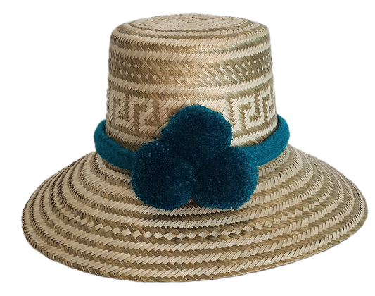Boho Wayuu straw hat in natural tones with subtle gold accents, adorned with teal pom-poms and a matching braided band — a handcrafted bohemian fashion accessory with colorful artisan charm.