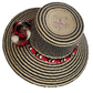 Colorful boho straw hat handwoven by Wayuu artisans, featuring a black and natural pattern, red-and-white braided band, and vibrant pom-poms — a bohemian fashion accessory perfect for summer.