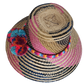 Boho Wayuu straw hat with vibrant pink, navy, and natural woven design, a multicolor braided band, and playful pom-poms in turquoise, red, and orange — a colorful, handcrafted bohemian summer accessory.