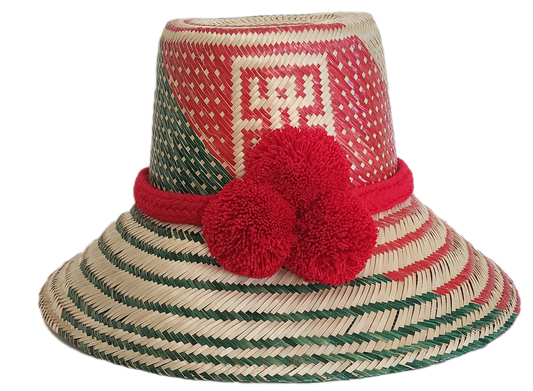 A vibrant, bohemian  handmade straw hat featuring red and green geometric patterns and a bold red pompom band with three fluffy pompoms.