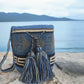 A vibrant and colorful crochet bag featuring boho-inspired Wayuu patterns. The bohemian-style accessory is intricately handcrafted with a multitude of bright, vivid colors, showcasing traditional Wayuu designs in a stylish, modern crochet technique.