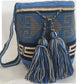 A vibrant and colorful crochet bag featuring boho-inspired Wayuu patterns. The bohemian-style accessory is intricately handcrafted with a multitude of bright, vivid colors, showcasing traditional Wayuu designs in a stylish, modern crochet technique.