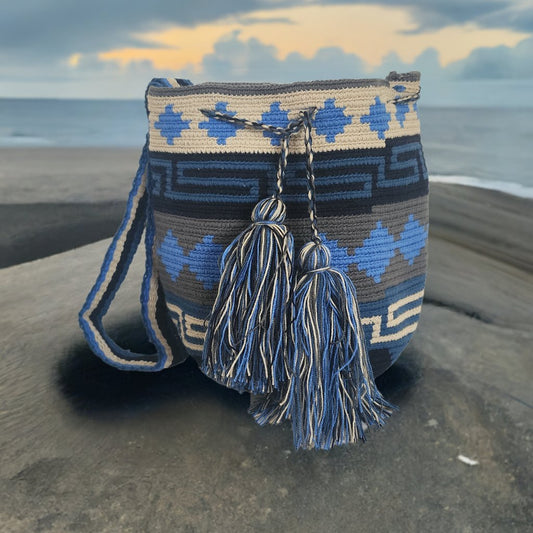 A vibrant, colorful crochet bag featuring a boho-inspired Wayuu design. The handmade piece showcases intricate patterns typical of Bohemian style, with a rich palette of bright, eye-catching colors. Ideal for adding a touch of artisanal charm to any outfit.