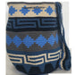 A vibrant, colorful crochet bag featuring a boho-inspired Wayuu design. The handmade piece showcases intricate patterns typical of Bohemian style, with a rich palette of bright, eye-catching colors. Ideal for adding a touch of artisanal charm to any outfit.